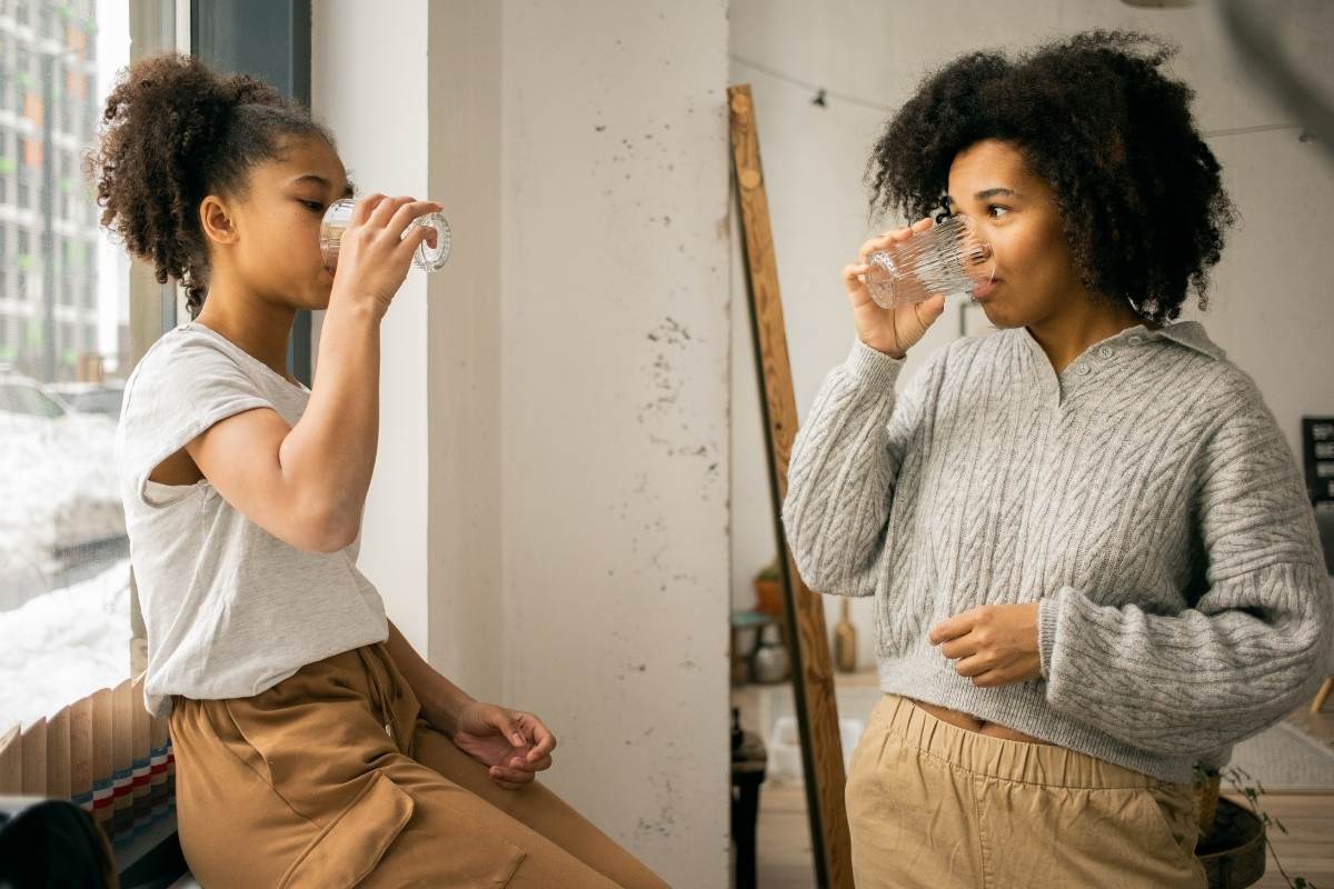 a woman and teen drinking a healthy drink and talking