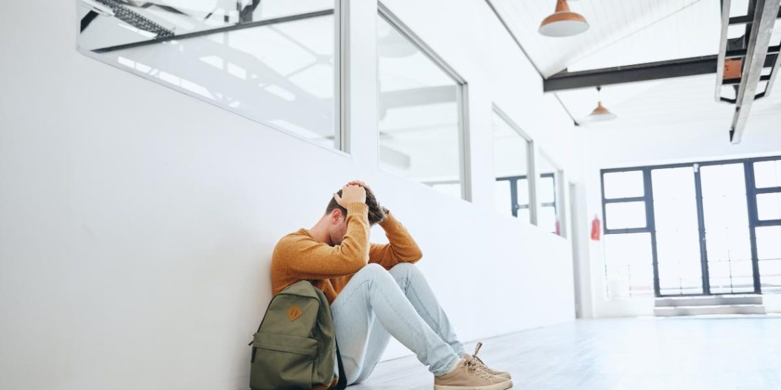 student sitting stressed in hallway